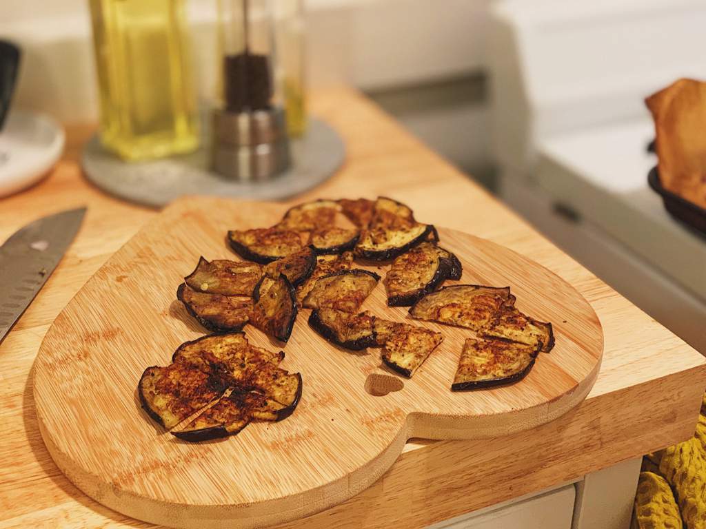 Roasted eggplant rounds with olive oil, balsamic vinegar, salt, and pepper sliced into quarters.
